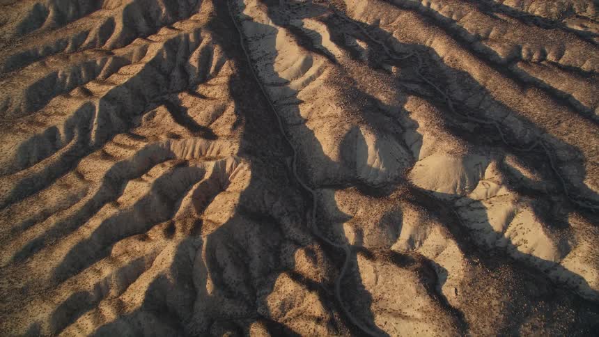 An aerial view of rugged terrain with patterns of erosion