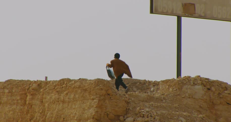 A man climbs up the hill by the overpass