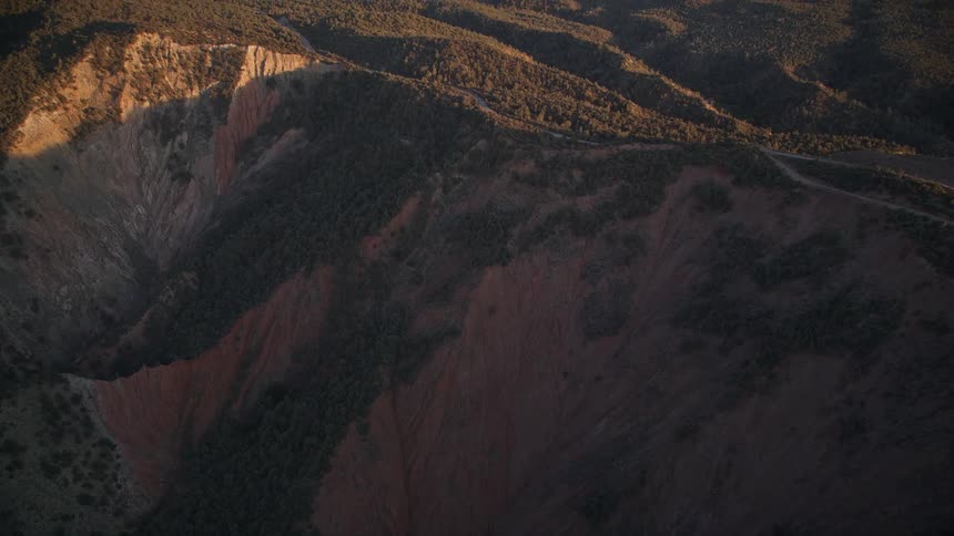 An aerial view of a mountainous landscape with shadows at morning