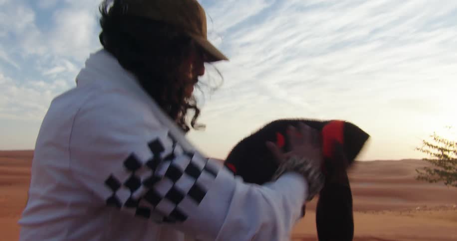 A man shakes sand out of his clothing