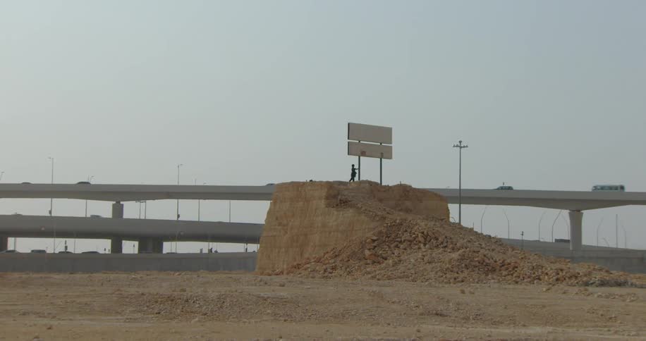 Person on top of a ravine next to a highway