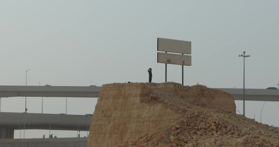 Man in fashionable clothes at the top of a ravine and between signs