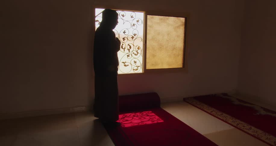 A man stands in prayer inside a mosque