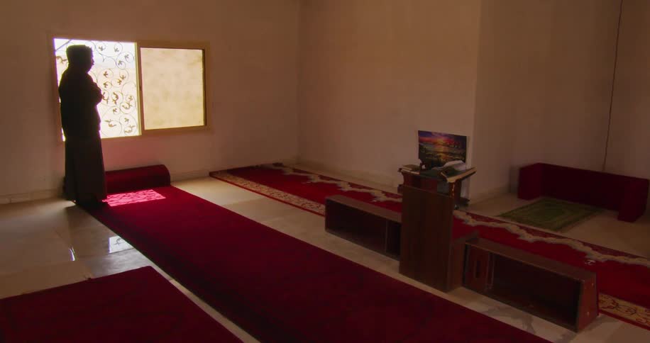 A person is praying by the window