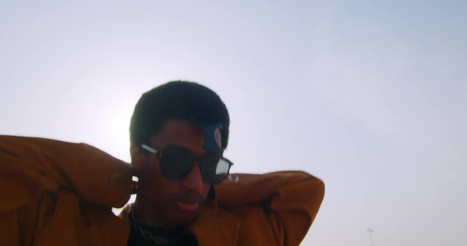 Model man wearing sunglasses putting a chain around his neck