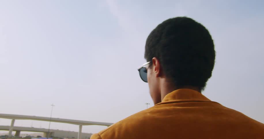 A young fashionable man wearing sunglasses and yellow jacket
