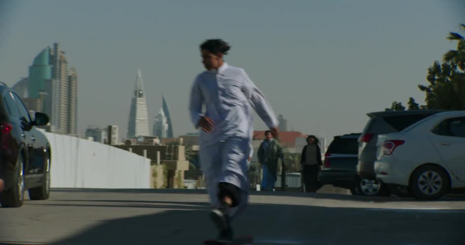 A group of friends wearing long robes skateboarding in the city