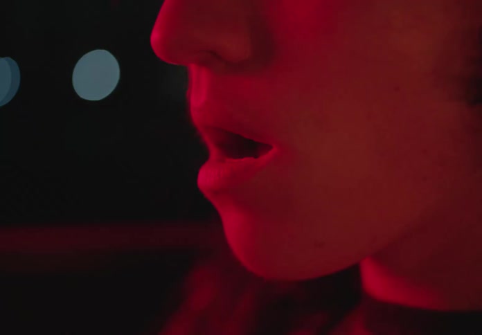 A man with mouth open bathed in red light