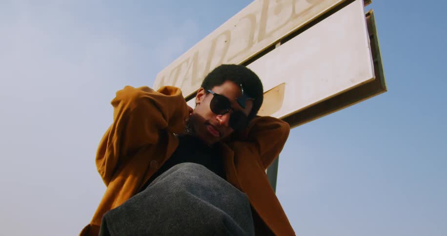 Portrait of a young man with sunglasses removing the chain that is around his neck