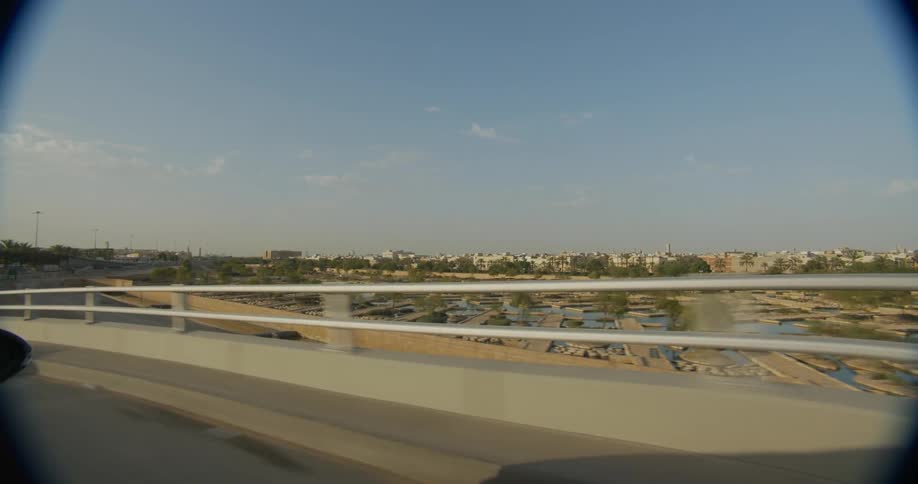 A cityscape seen through a car window showcasing urban buildings and streets