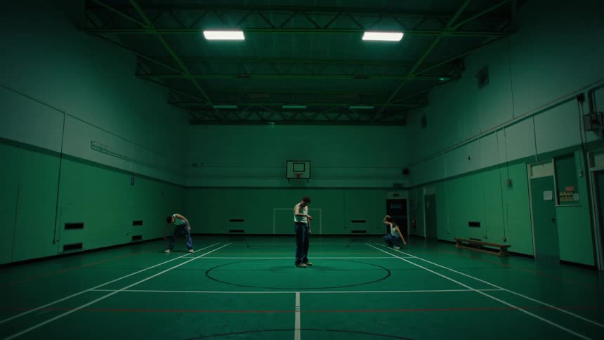 Multiple exposures of a man inside a lit court dancing