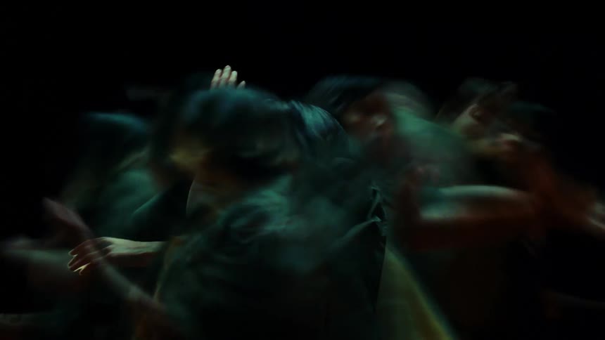 A woman with several copies of herself moving quickly around her