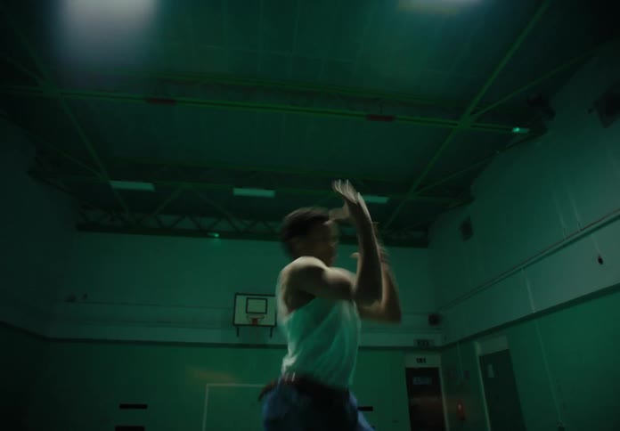 A young man dances in a school gym