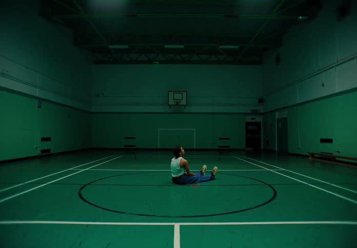 Man sitting in the center of a basketball court