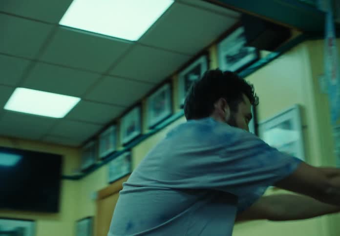 Male dancer with a beard and a blue t shirt dances in a store