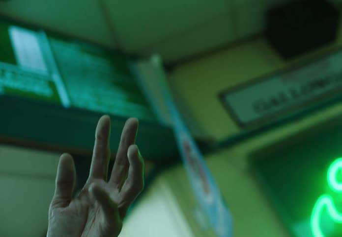 A man extends his hand and flexes it inside of a restaurant