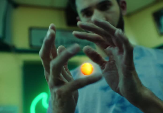 Concentrated man shaping a sphere that floats in his hands