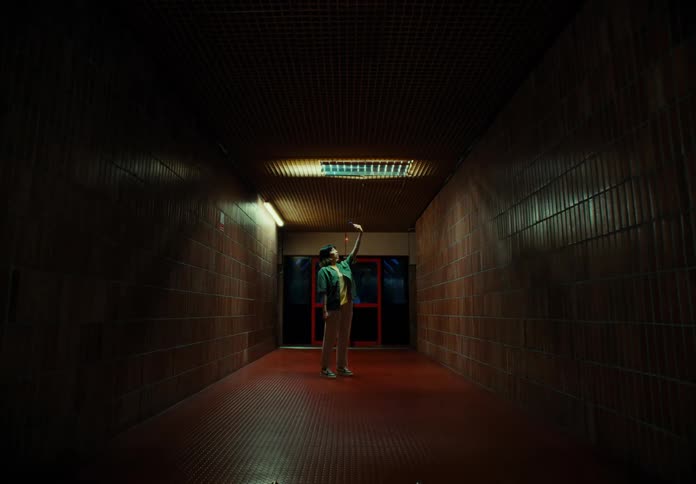 A woman taking a selfie in a dimly lit hallway