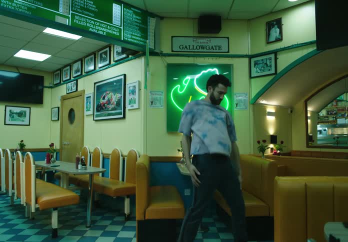 A man inside a coffee shop is doing dance moves moving his whole body