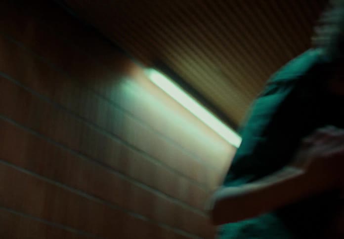 Close up of a woman dancing in a dimly lit corridor