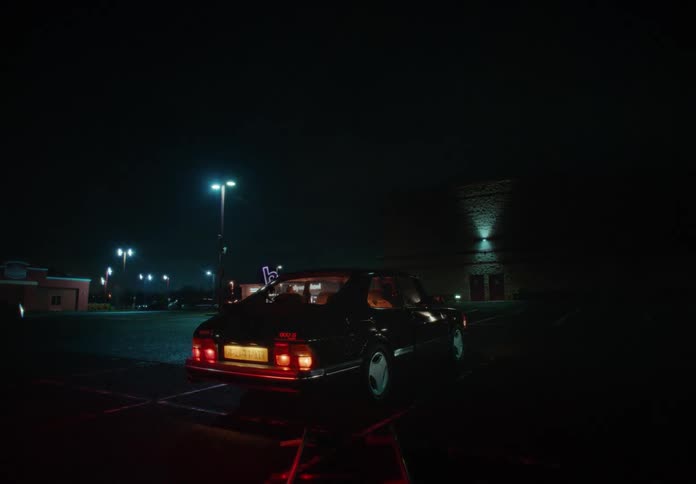 A car is parked in the parking lot at night