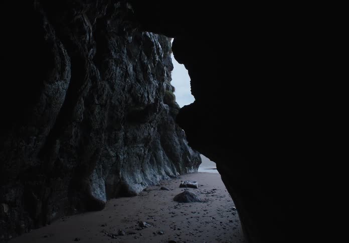 The cave by the shore is dark