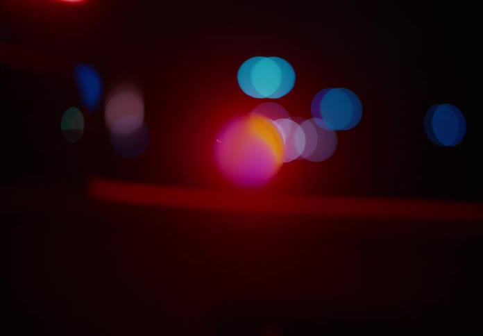 Colorful orbs float in the air in a dark room