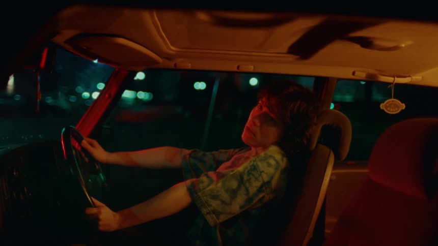 A woman sitting in a van at night is strangely rocking back and forth