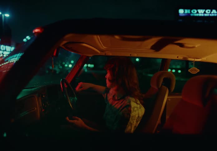 A man sits in a van moving his hands and arms in slow motion
