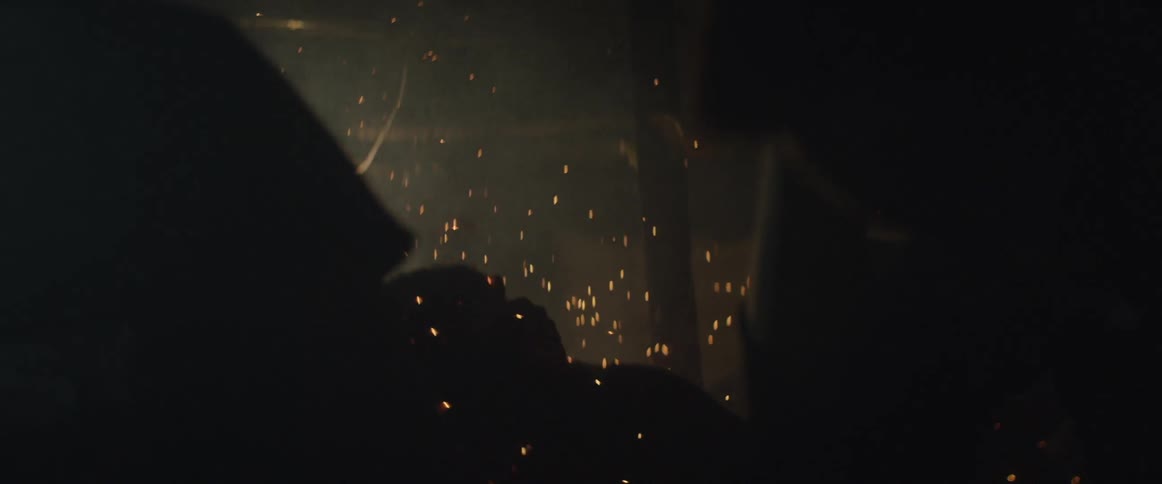 People duck away from sparks at night