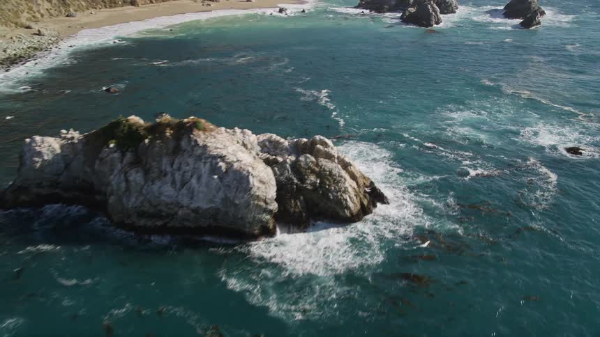Aerial view of coastal beach with multiple rock formations