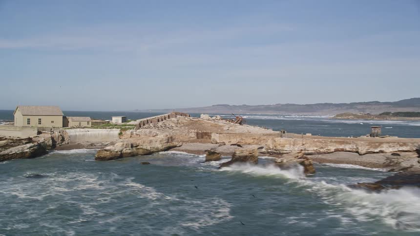 Aerial panorama of an island with small isolated houses in the middle of the sea
