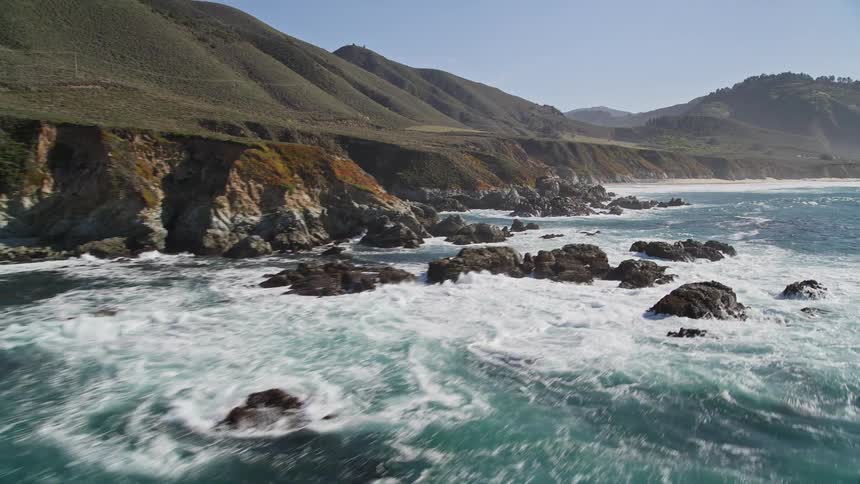 Aerial panorama of an extensive ocean with smoky waves at the shore