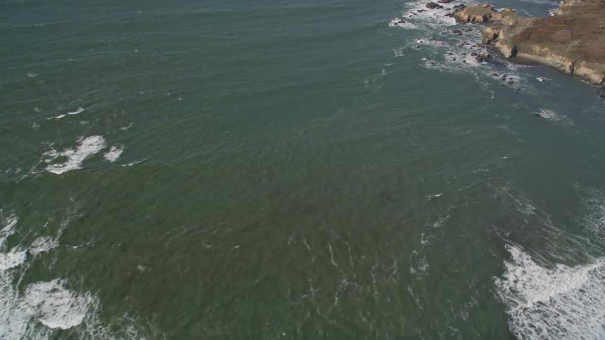 Rocky terrain on the edge of a vast sea with waves