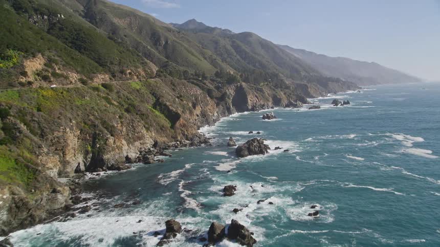 The rugged cliffs jut out into the deep blue ocean creating a dramatic seascape