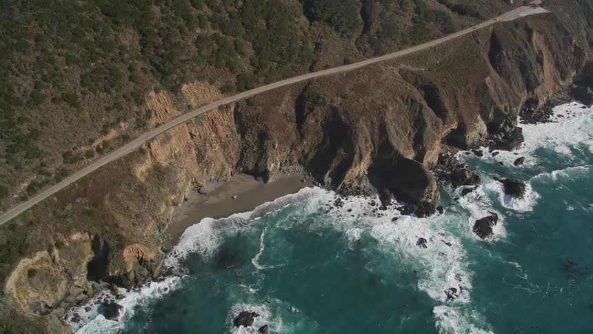 Panorama of a rocky mountain with a long road and the seaside