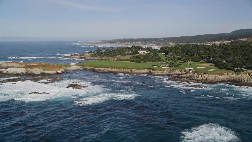 The waves break against the rugged cliffs of a rocky coastline creating a dramatic scene