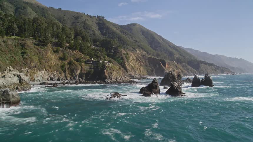 Green mountains on the edge of a vast blue sea