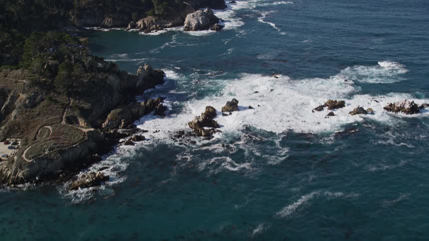 Peninsula with a rocky wooded coastline surrounded by beaches and sea