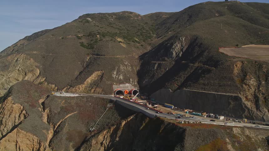 Aerial of a tunnel construction project on a coastal highway on a mostly sunny day