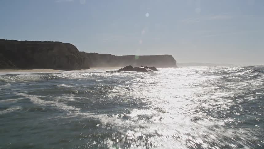 Solar reflection in an extensive ocean with a rocky crust on the horizon