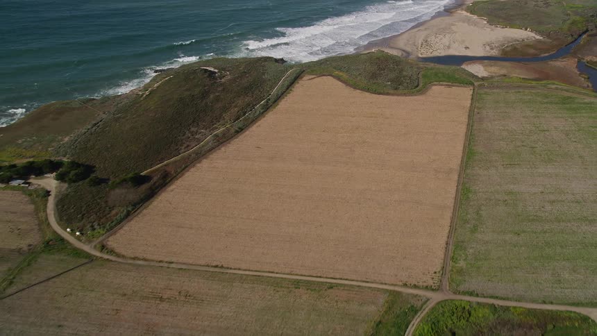 Aerial panorama of mountains with agricultural fields and seaside