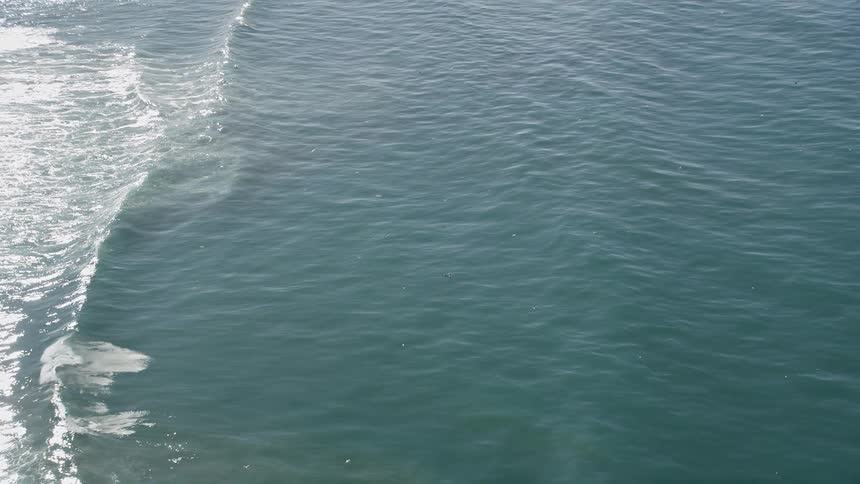 Ocean with calm waves and the reflection of sunlight