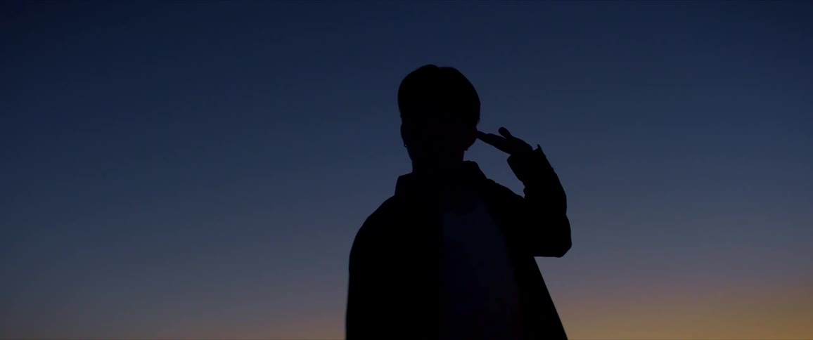 Blue and yellowish sky and the silhouette of a man dancing