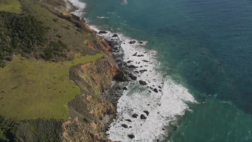 Landscape of a turquoise blue sea on the edge of green mountains