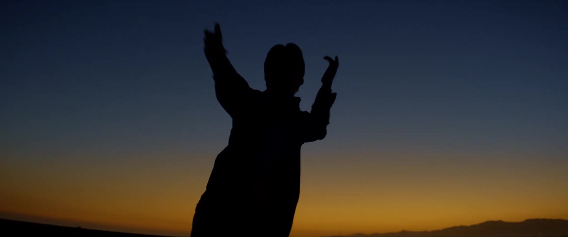 Blue and yellowish sky on the horizon and the silhouette of a person dancing