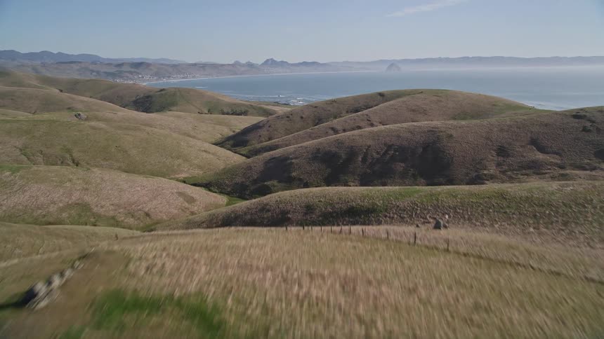 Aerial panorama of a mountain range with vegetation by the sea