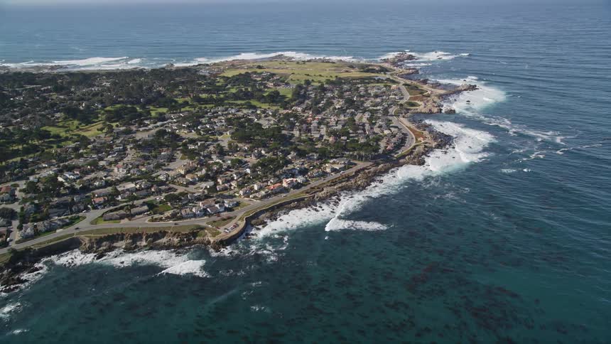 Highway passing around residential neighborhood on a small peninsula parallels the coast