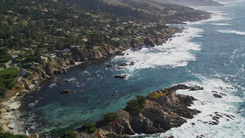 Aerial view of a rugged coastline with houses nestled among rocky outcrops