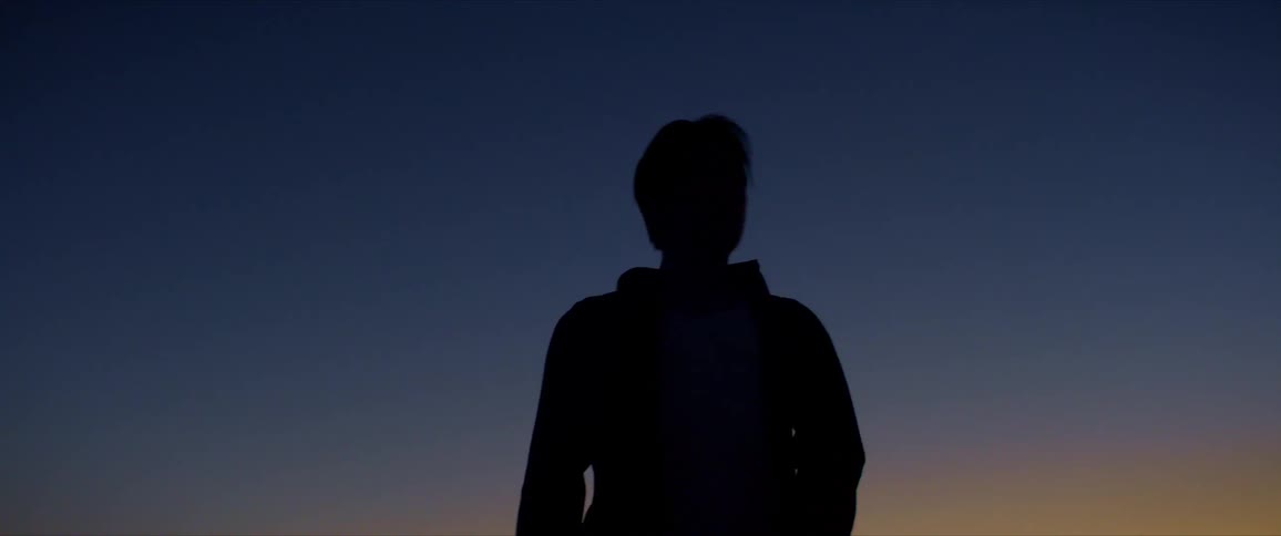 Upward view of silhouette of a man in an open air environment dancing